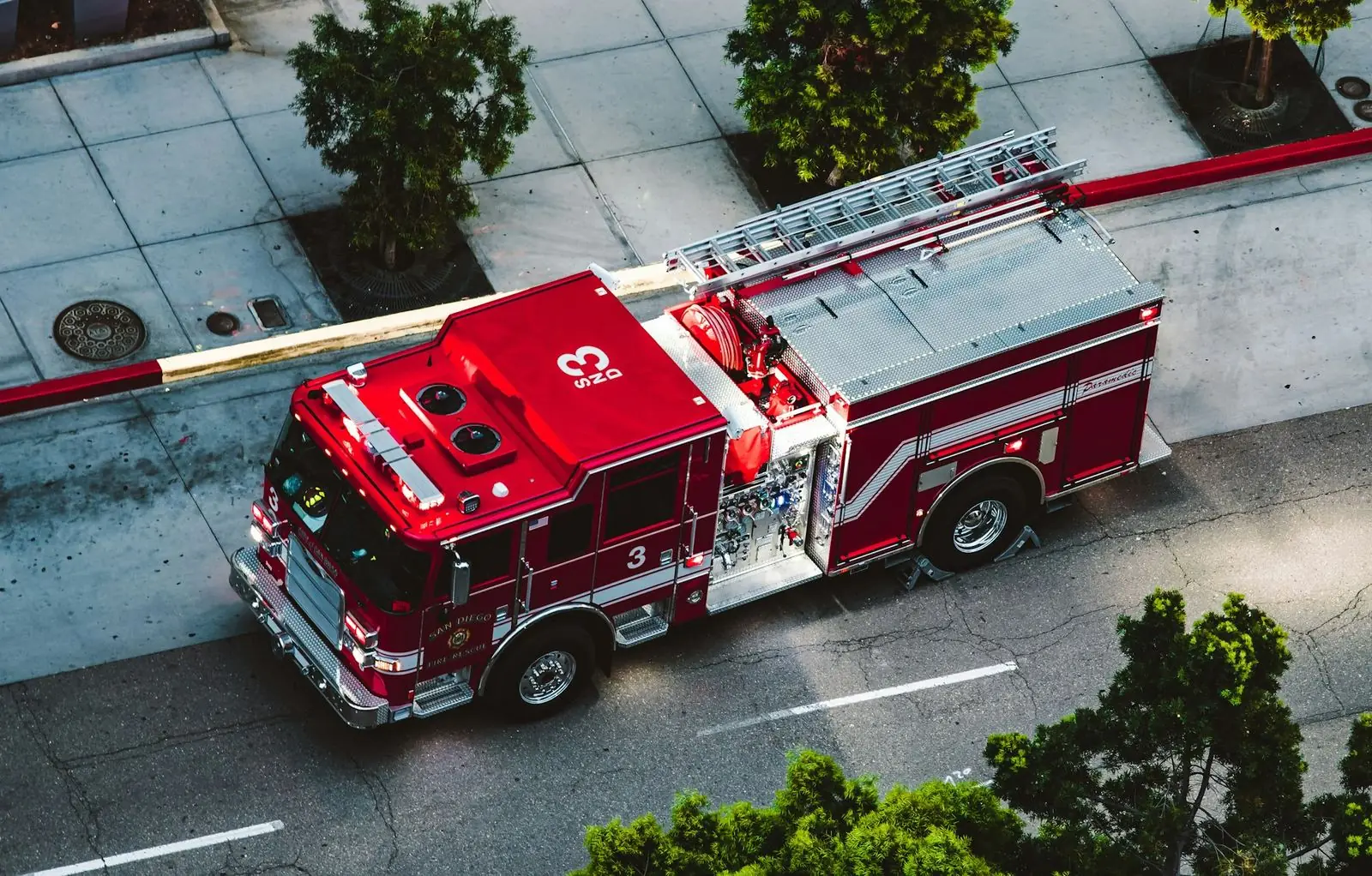 Overhead view of a red aerial ladder fire truck on a city street